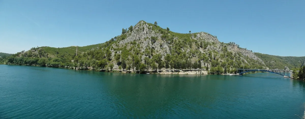 Calm green water and limestone rock walls in the Krka river canyon near Skradin, Croatia